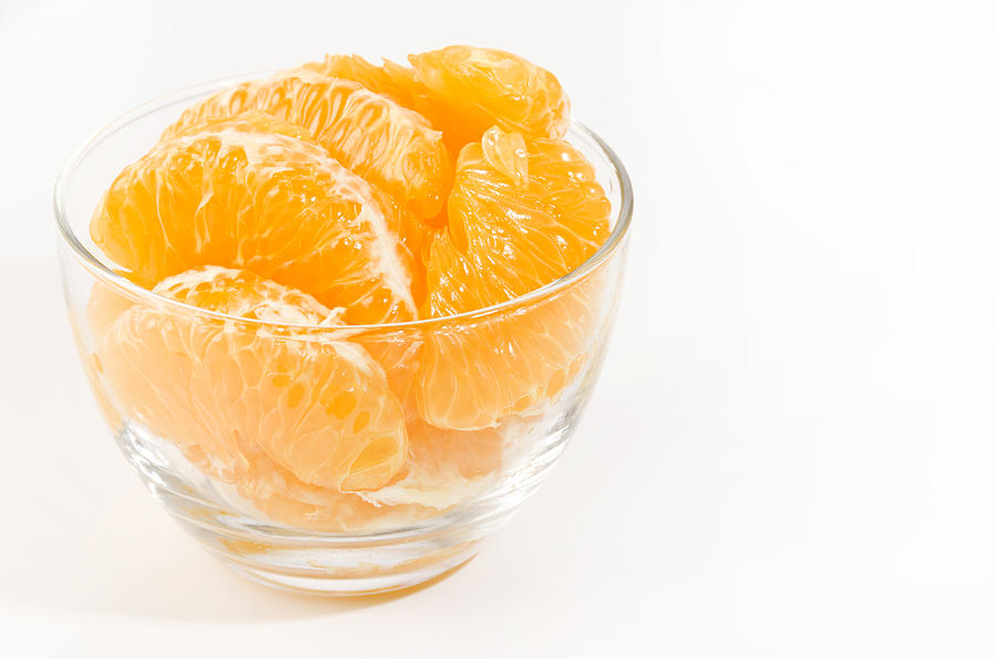 Fresh peeled Hassaku Orange in Transparent Glass bowl on white background Photograph by Karimitsu