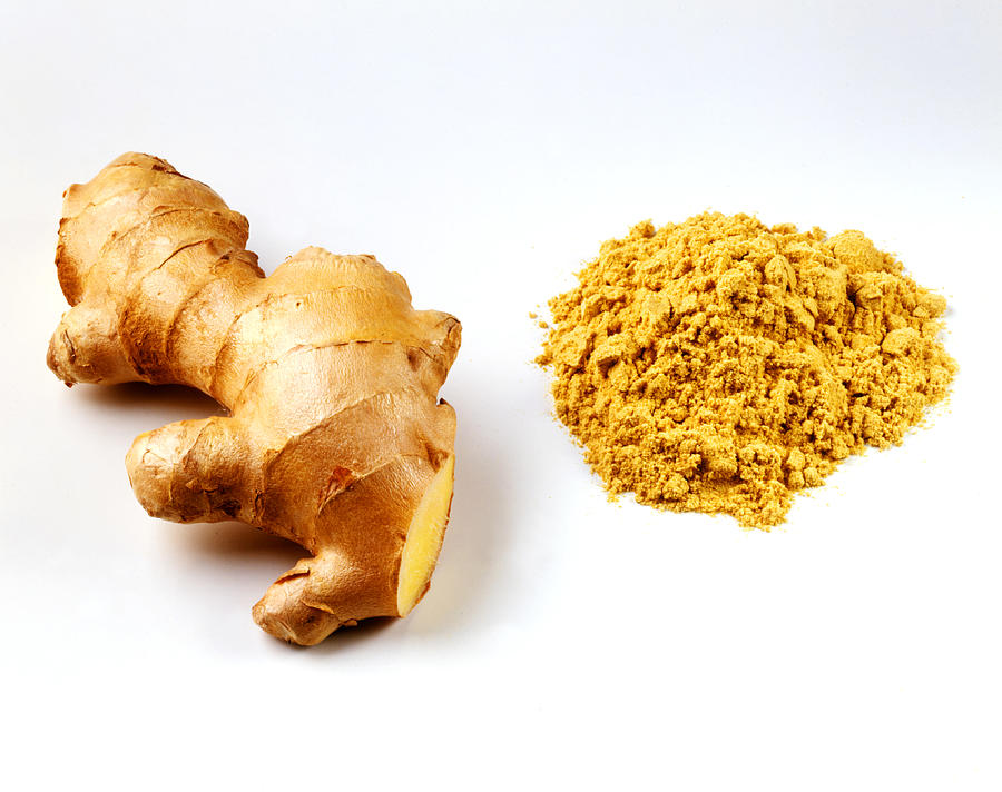 Fresh root ginger with pile of ginger powder Photograph by Joff Lee