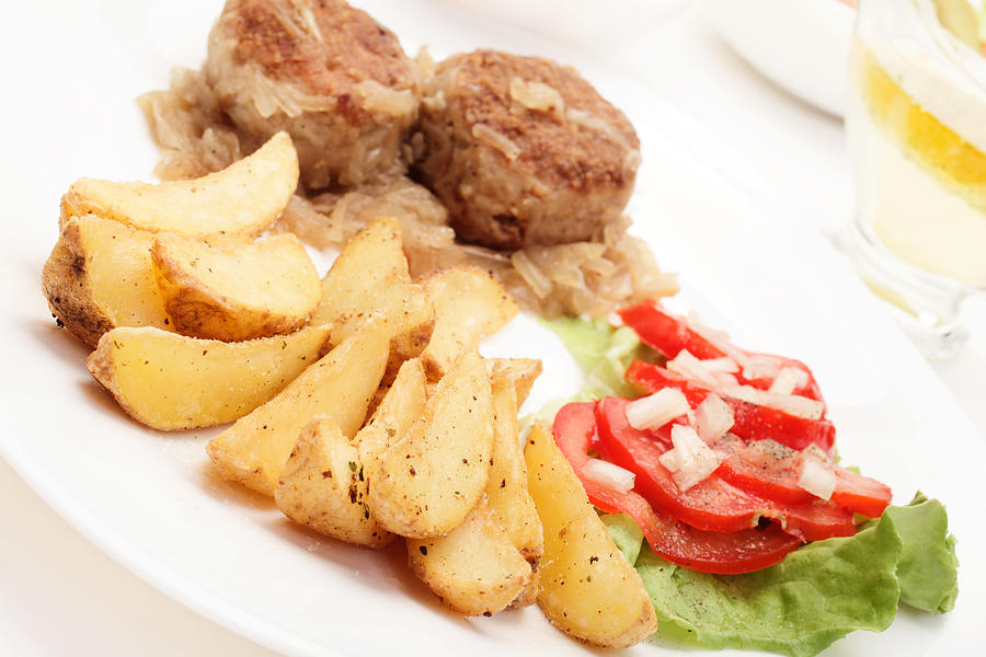 Fried potato wedges with meatball and vegetable salad Photograph by Fotek