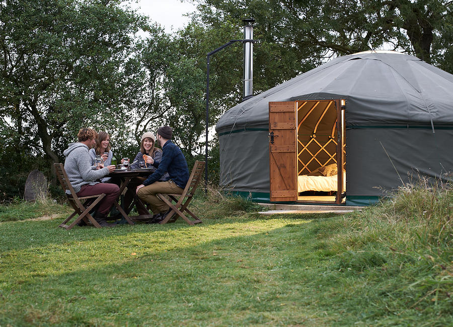 Friends enjoying company over dinner outside yurt. Photograph by Mike Harrington