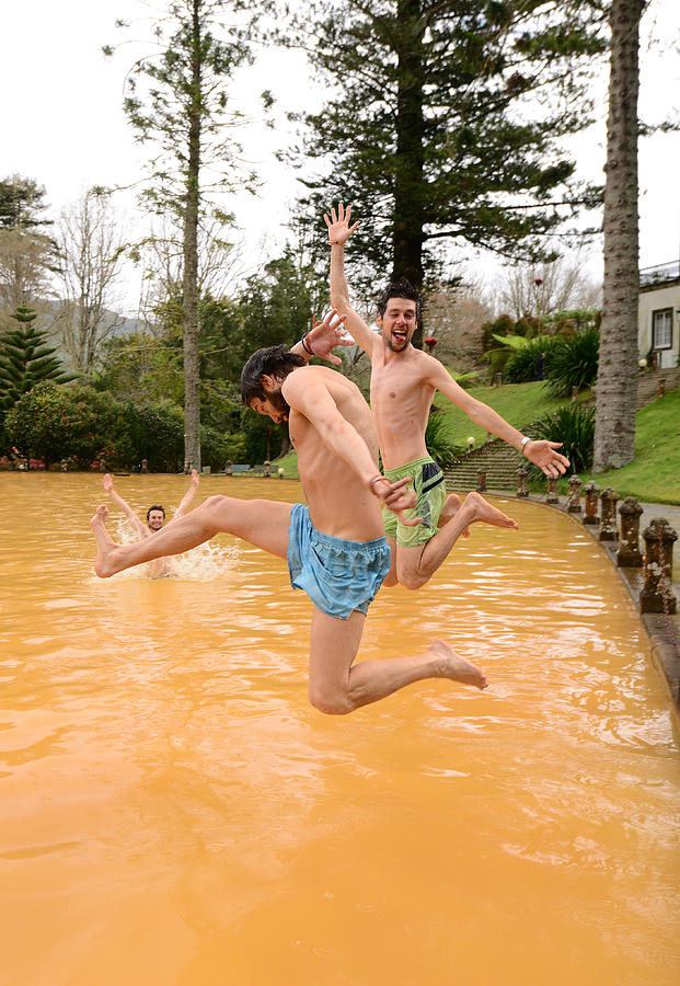 Friends having fun and jumping into volcanic hot springs Photograph by Maya Karkalicheva