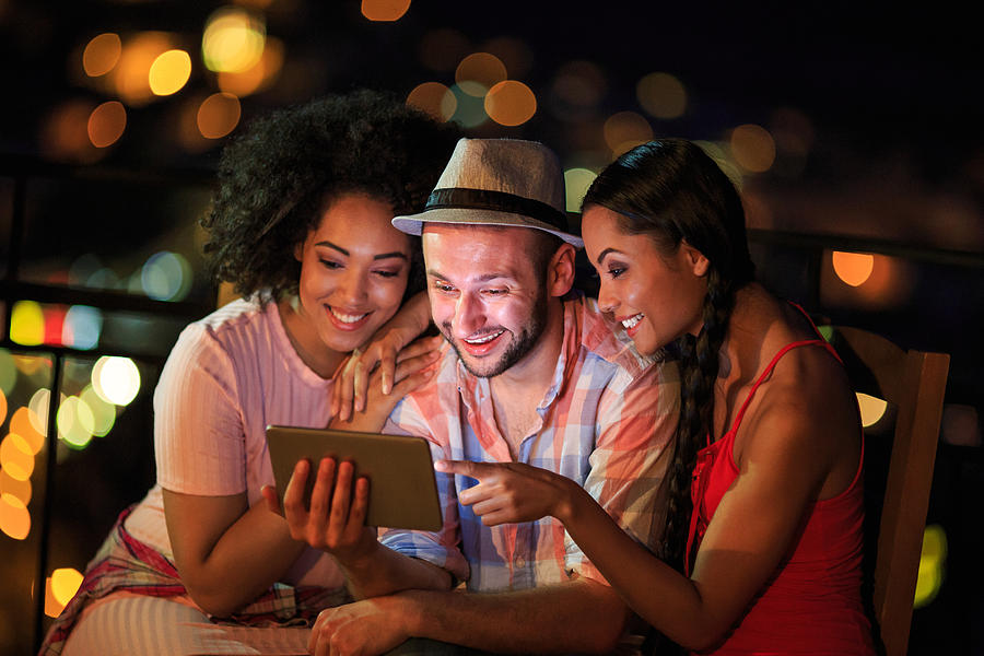 Friends having fun and using tablet at night Photograph by Valentinrussanov