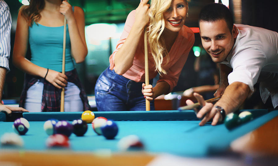Friends shooting pool. Photograph by Gilaxia
