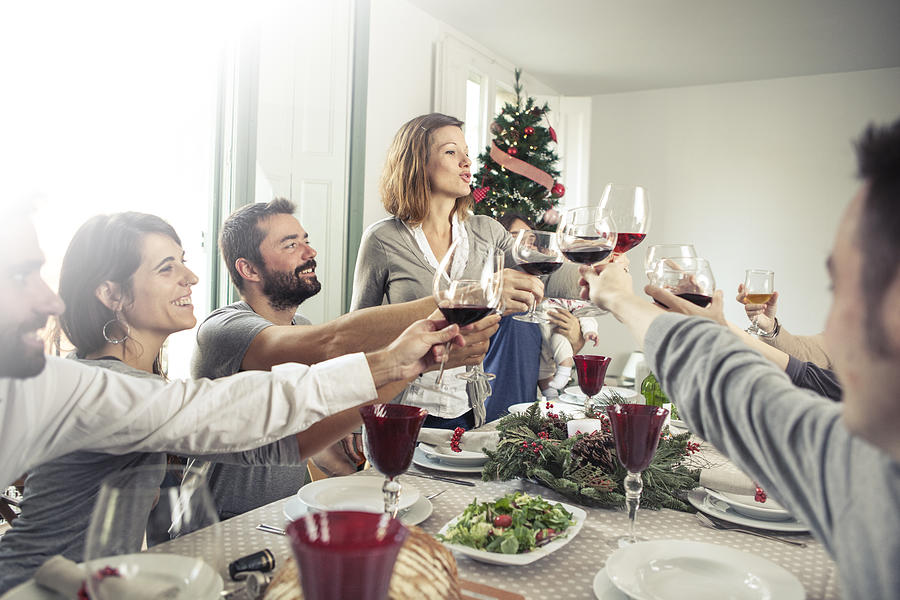 Friends toasting at Christmas dinner Photograph by Orbon Alija