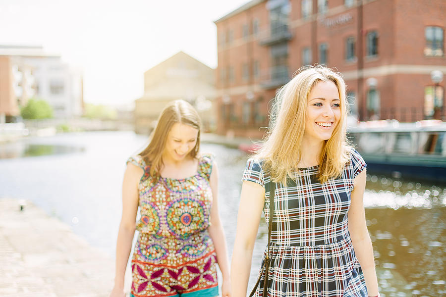 Friends walking by canal, Leeds, England Photograph by Mark Webster