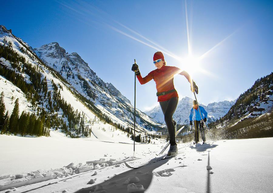 Front-view of two female nordic skiers skiing. Photograph by Tyler Stableford