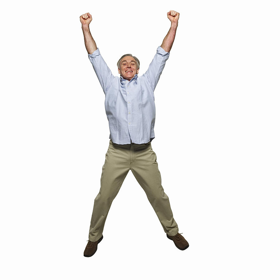 Front view portrait of mature man jumping into the air with arms raised Photograph by George Doyle & Ciaran Griffin