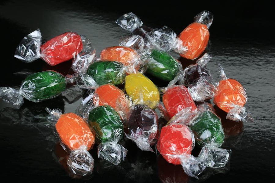 Fruit flavored candies on a black background Photograph by Douglas Sacha