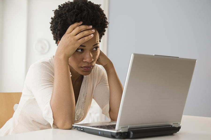 Frustrated Black businesswoman using laptop Photograph by JGI/Jamie Grill