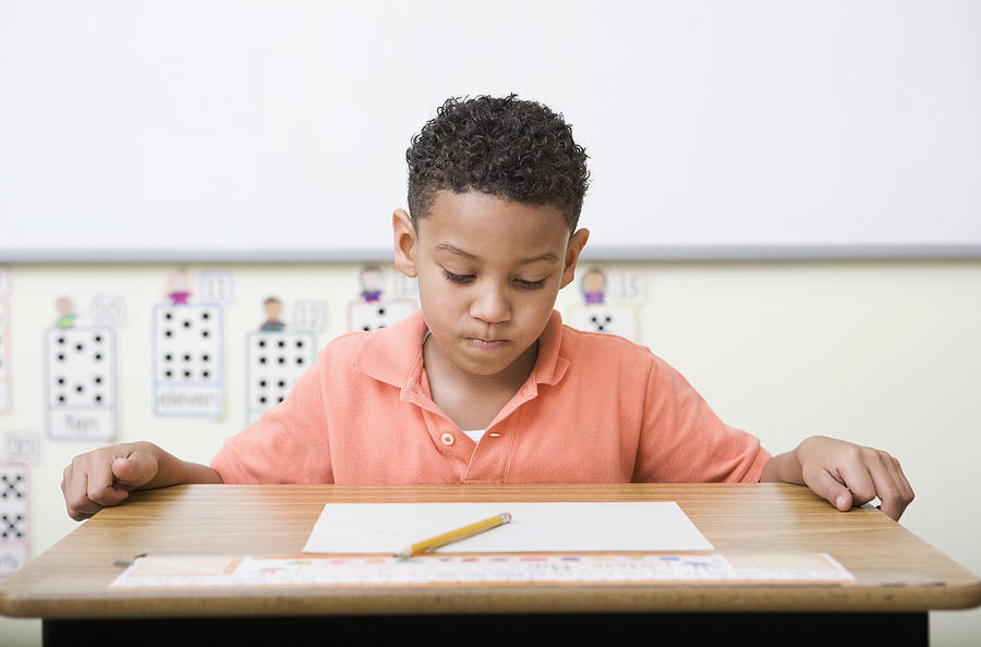 Frustrated boy looking at test in classroom Photograph by Wealan Pollard