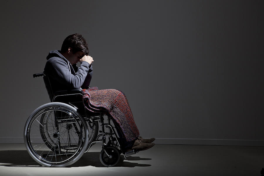 Frustrated Caucasian man in wheelchair Photograph by Walter Zerla