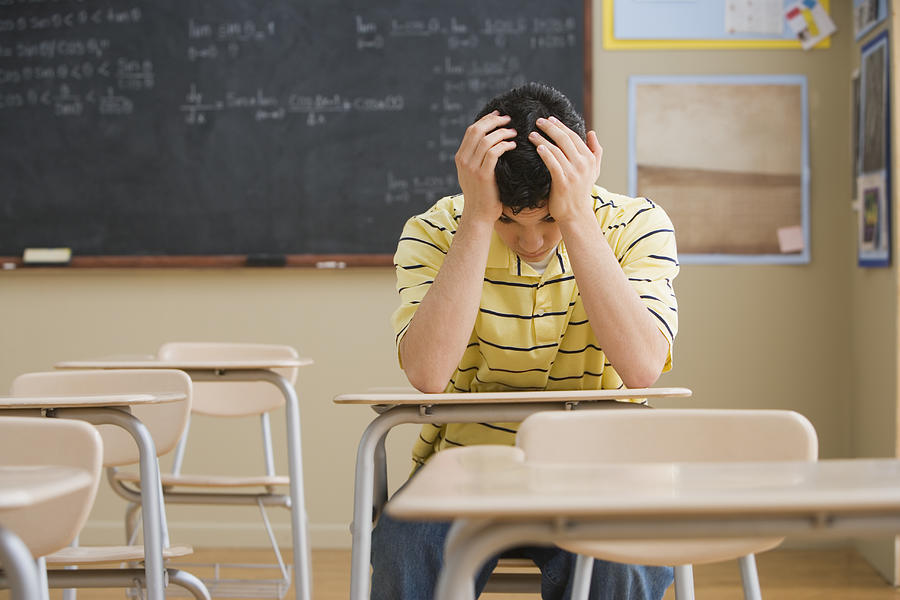 Frustrated Teenage Boy in Classroom Photograph by Fuse