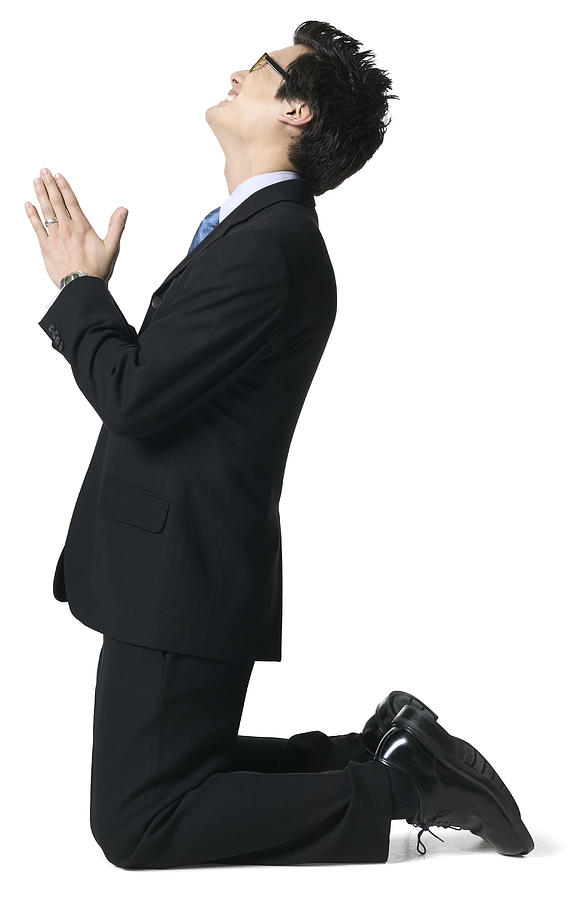 Full Body Portrait Of A Young Adult Male In A Suit As He Gets Down On His Knees And Begs Photograph by Photodisc