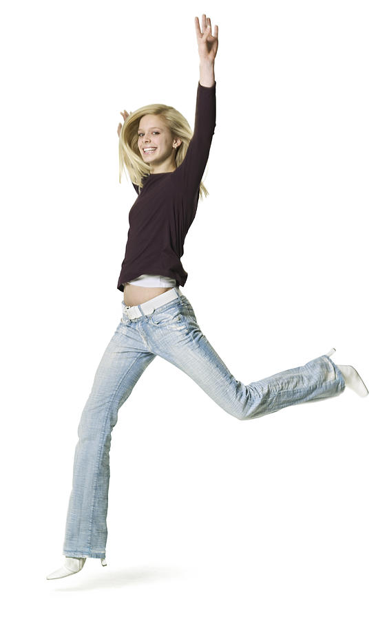 Full Body Shot Of A Blonde Teenage Female In A Purple Shirt As She Runs And Jumps Through The Air Photograph by Photodisc