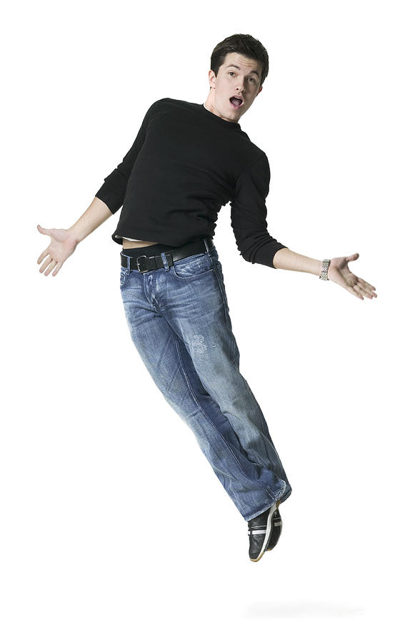 Full Body Shot Of A Young Adult Male In A Black Shirt As He Playfully Jumps Up Photograph by Photodisc