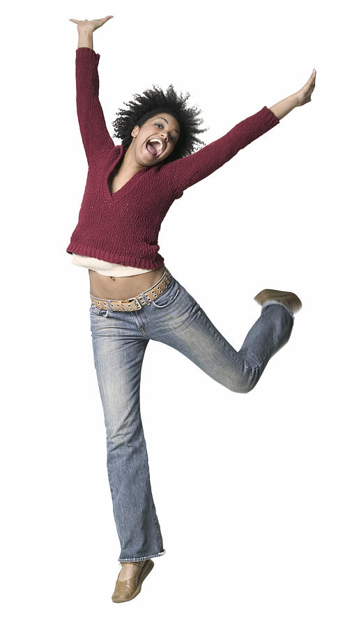 Full Body Shot Of A Young Adult Woman As She Playfully Jumps And Throws Up Her Arms Photograph by Photodisc