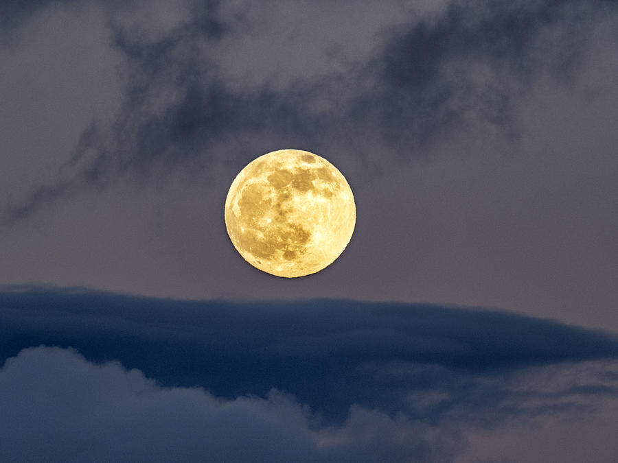 Full frame of the full moon at sunset with a sky with clouds. Photograph by Jose A. Bernat Bacete