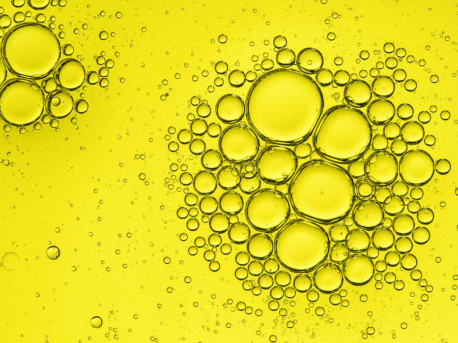 Full frame of the textures formed by the bubbles of oil in the shape of circle floating on the water color yellow Photograph by Jose A. Bernat Bacete