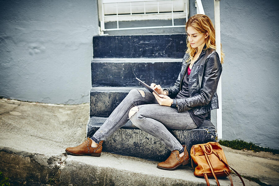 Full length of beautiful woman using digital tablet on steps Photograph by Neustockimages