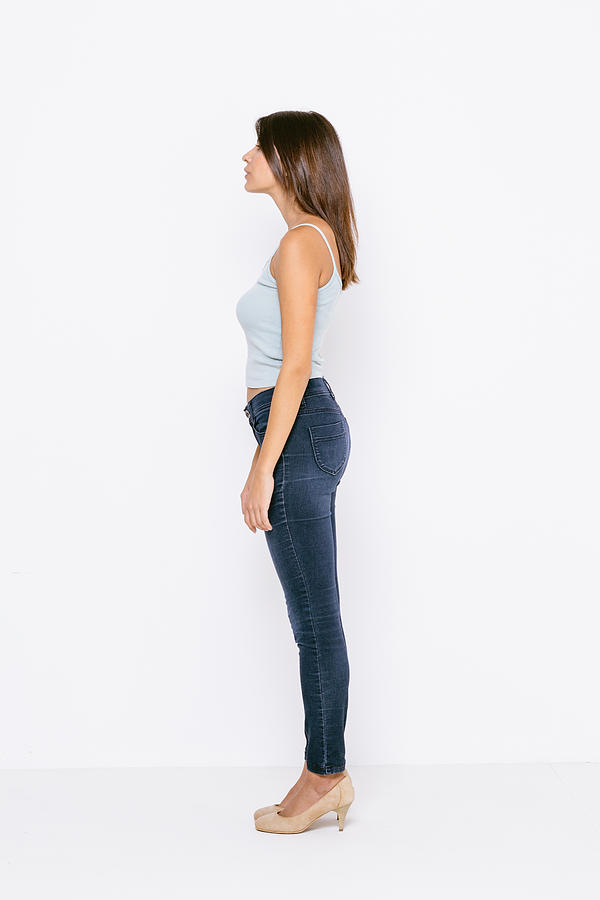 Full length side view of young woman wearing vest and skinny jeans Photograph by Innocenti