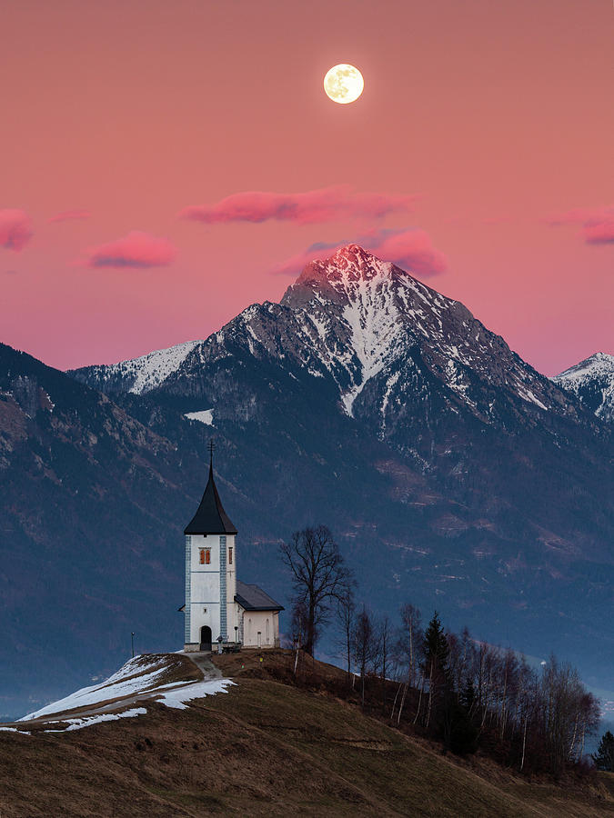 Full moon rising over Jamnik church and Storzic at sunset Photograph by Ian Middleton
