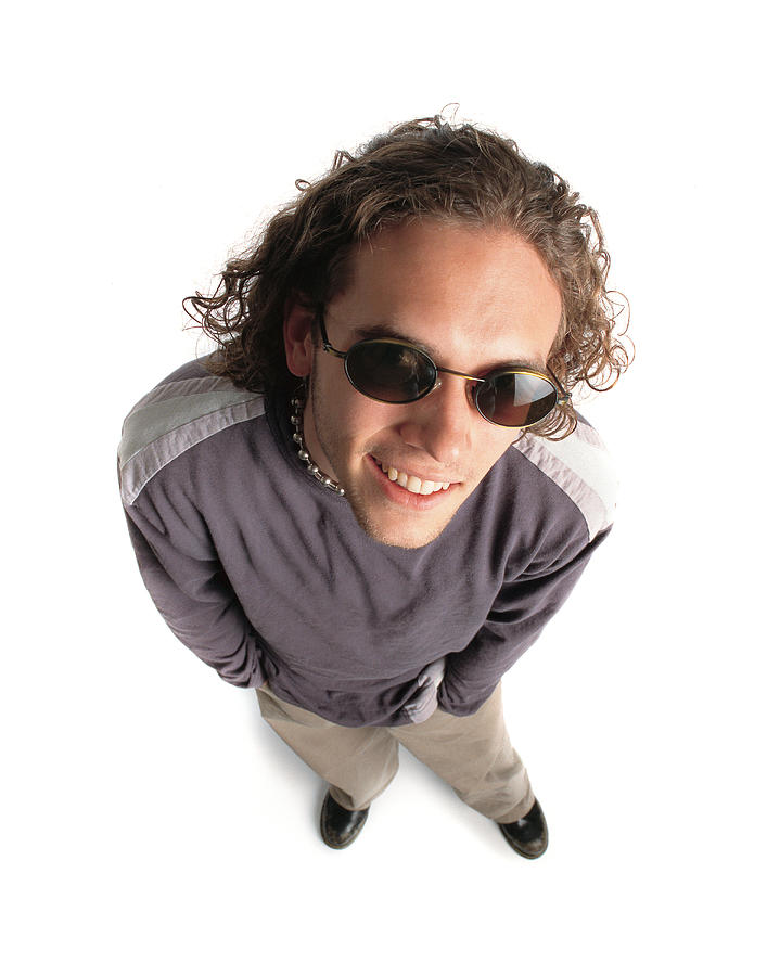 Funky Caucasian Male With Curly Brown Hair Wearing Alternative Style Clothing And Sunglasses Looks Up And Smiles Photograph by Photodisc