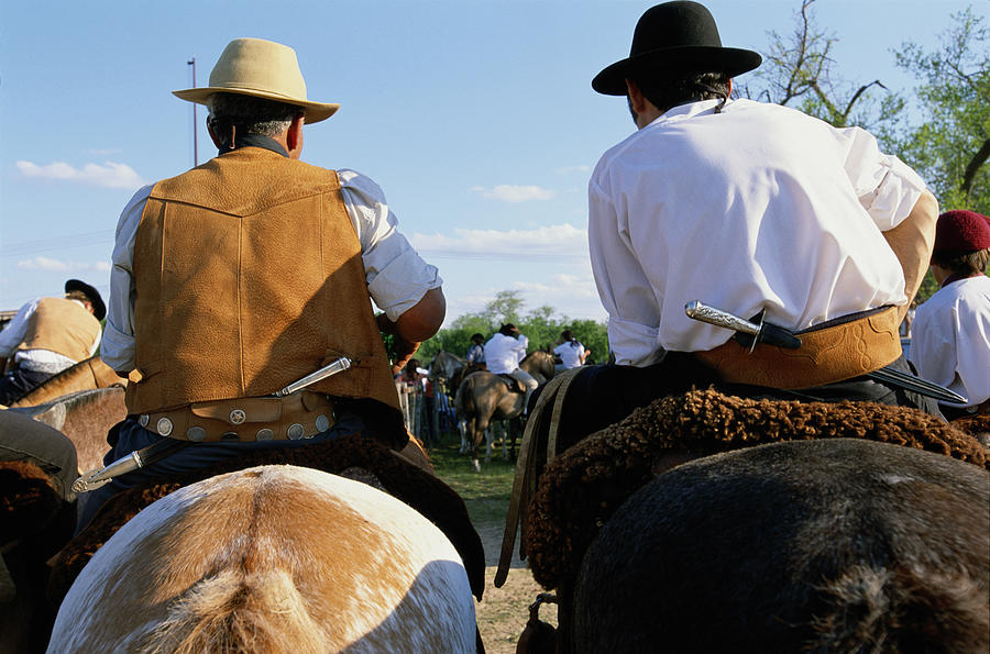 Gauchos on horseback, rear view Photograph by Peter Adams