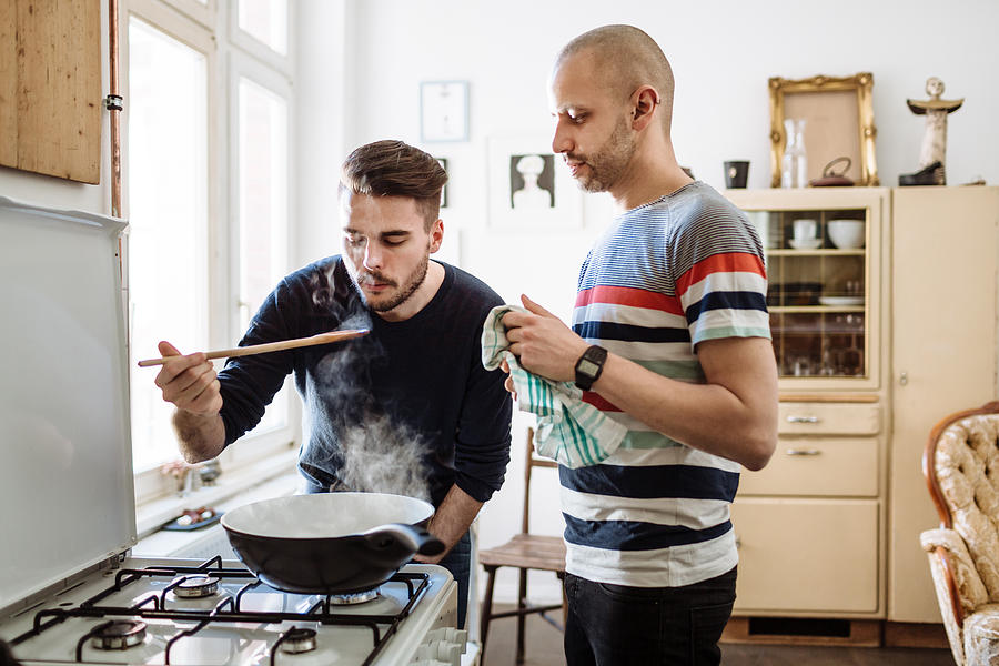 Gay Couple Cooking Together Photograph by Hinterhaus Productions
