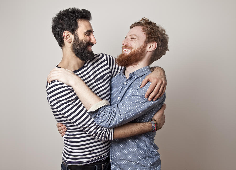 Gay couple hugging and laughing Photograph by Claudia Burlotti