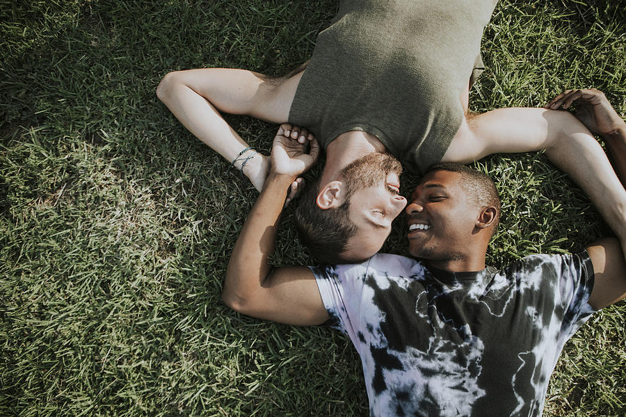 Gay couple relaxing in the grass Photograph by Rawpixel