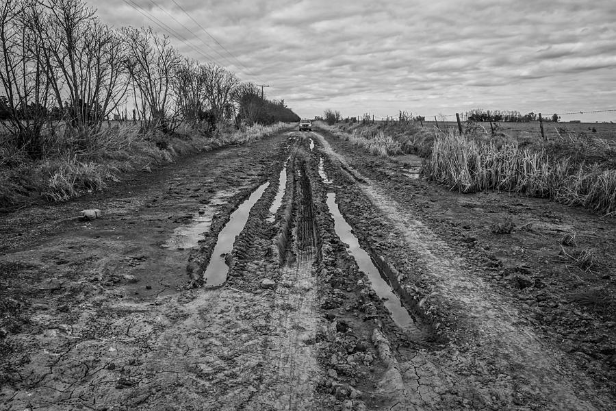 General view of a truck on a rural road in black and white Photograph by Andres Ruffo