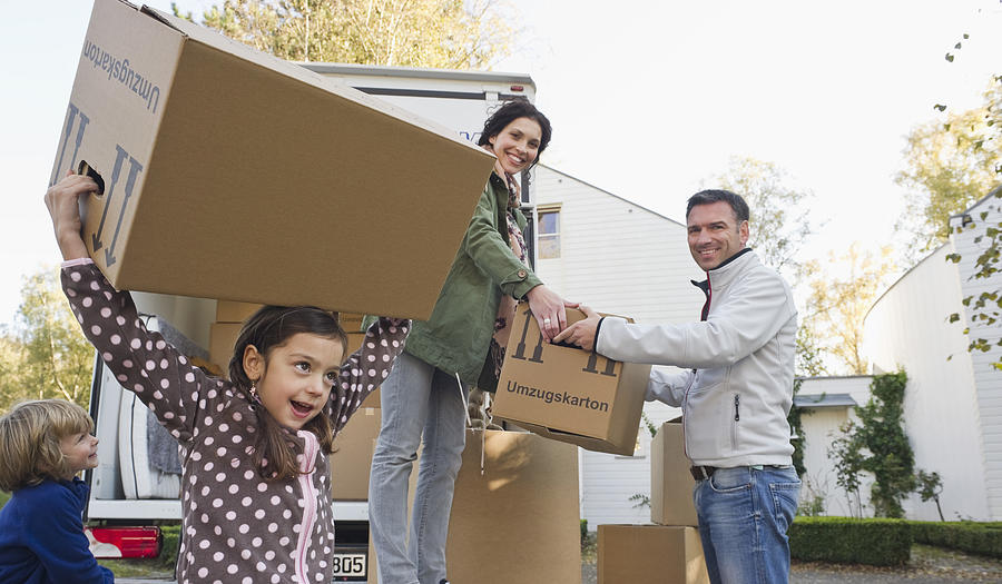 Germany, Bavaria, Grobenzell, Family with cardboard boxes for moving house, smiling Photograph by Westend61