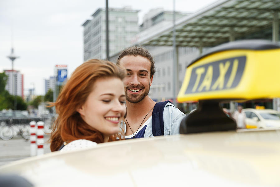 Germany, Berlin, Young couple taking taxi Photograph by Westend61