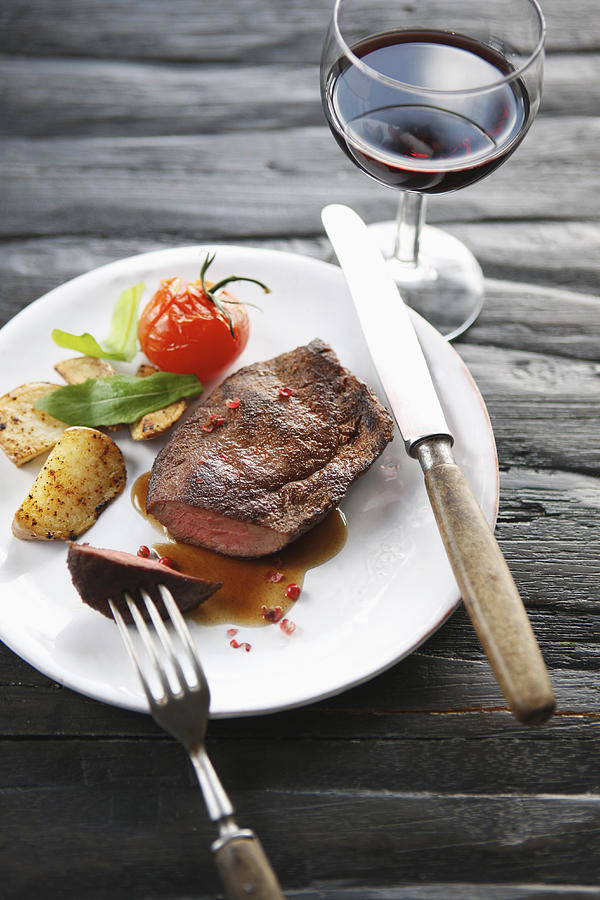 Germany, Bremen, Steak with vegetable and wine on table Photograph by Westend61