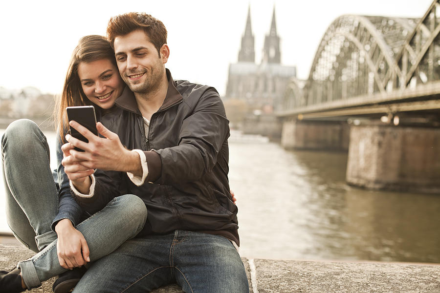 Germany, Cologne, young couple taking selfie in front of Cologne Cathredral Photograph by Westend61