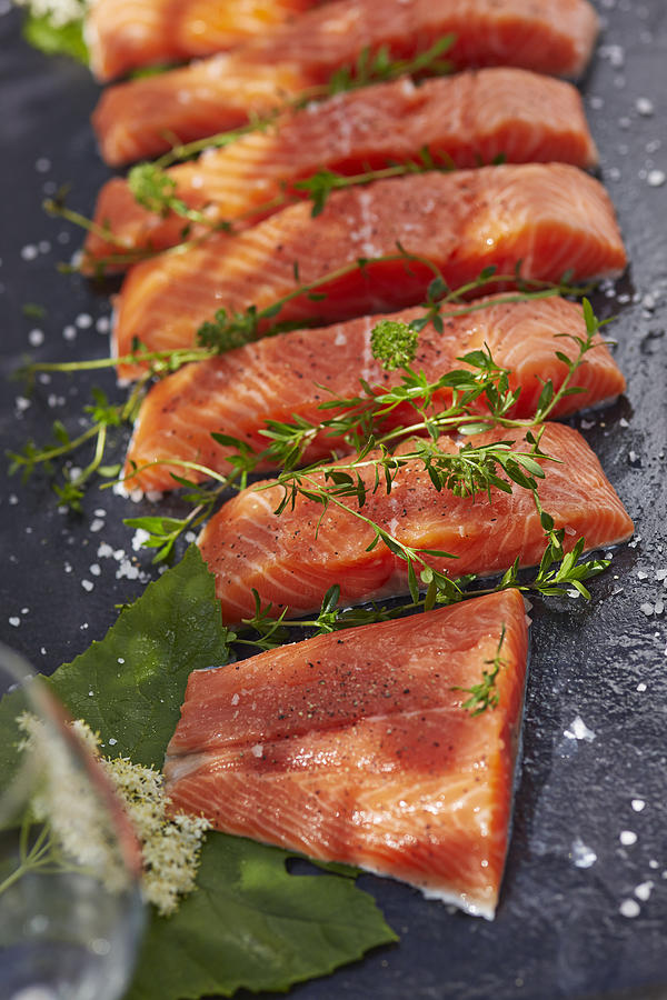 Germany, Pieces of salmon filet, Thyme and elderflowers Photograph by Westend61