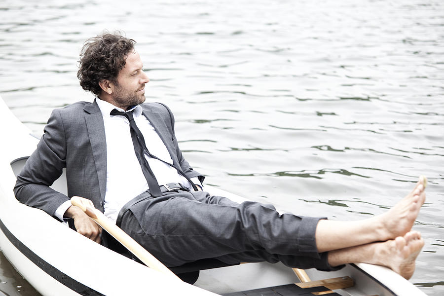 Germany, Rur Reservoir, businessman relaxing in canoe Photograph by Westend61