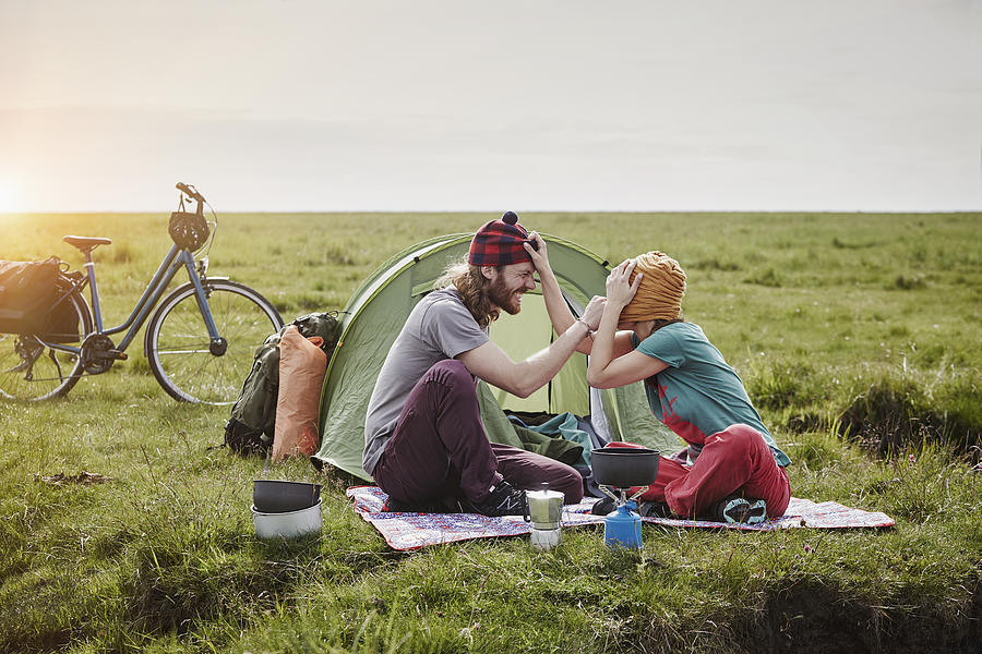 Germany, Schleswig-Holstein, Eiderstedt, playful couple with bicycles camping in marsh landscape Photograph by Westend61