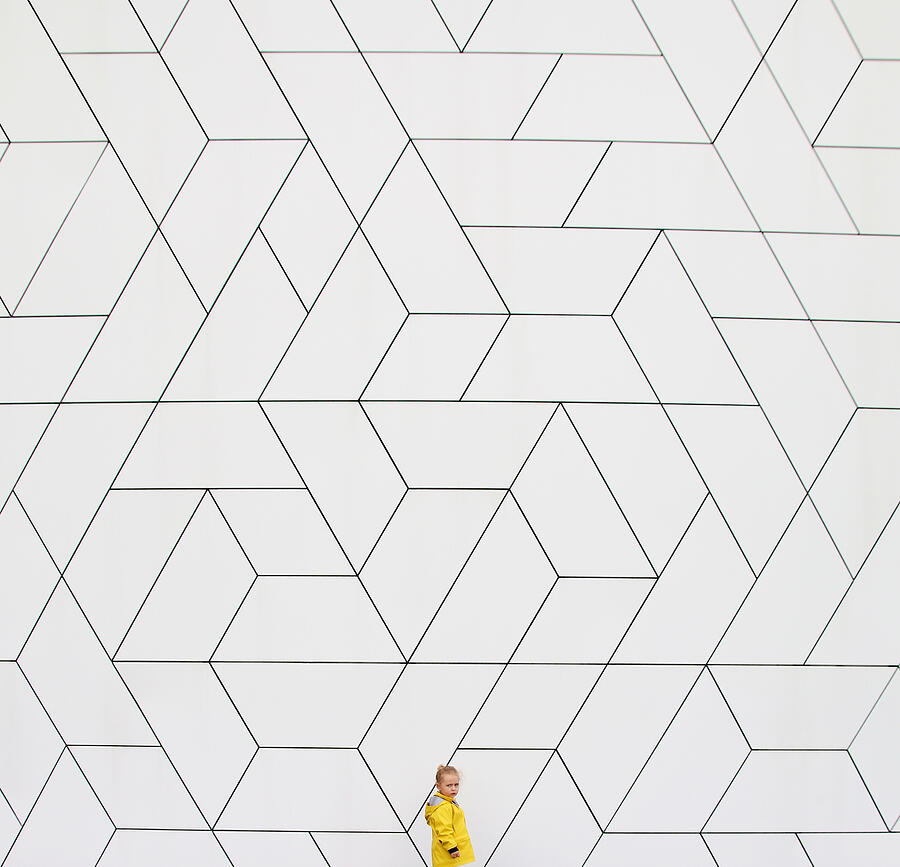 Girl (2-3) in yellow raincoat against white wall Photograph by Thatsval