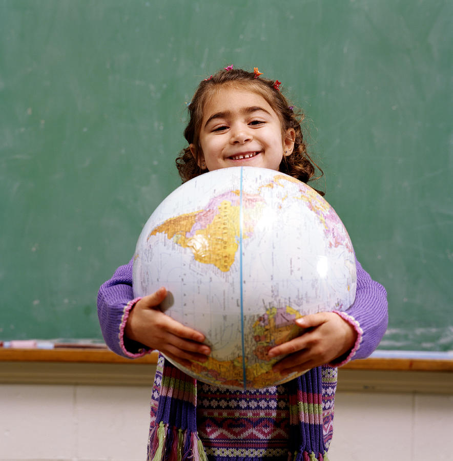 Girl (4-6) holding world globe, portrait Photograph by Ron Levine