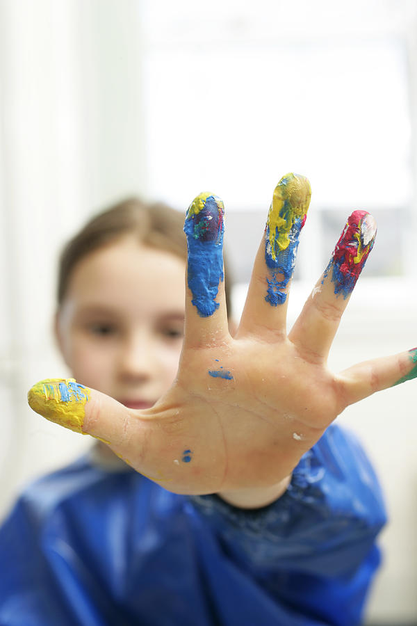 Girl (6-8) with paint on fingers, close up, portrait Photograph by Martin Poole