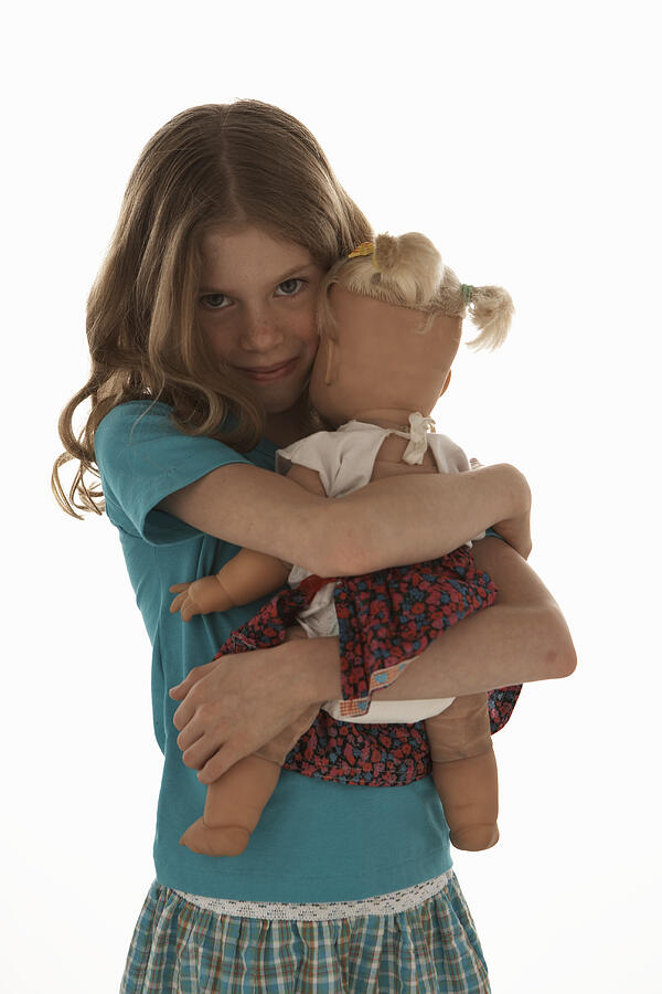 Girl (8-10) hugging doll, smiling, portrait Photograph by Thomas Northcut