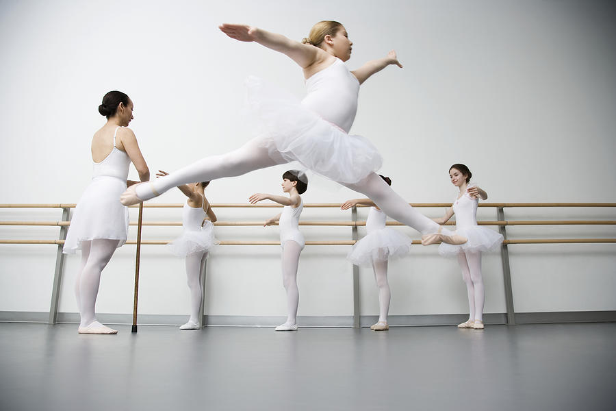 Girl (8-10) performing grande jete in ballet class Photograph by David Sacks