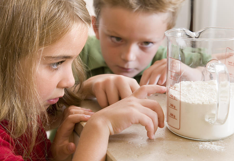 Girl And Boy Measuring Flour Photograph by Henglein & Steets