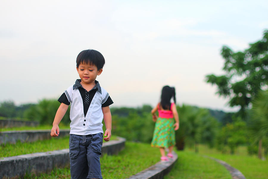 Girl and boy walking in opposite direction Photograph by AT Photography