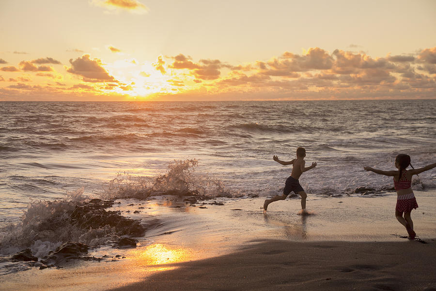 Girl and brother running on beach at sunrise, Blowing Rocks Preserve, Jupiter Island, Florida, USA Photograph by Kinzie Riehm