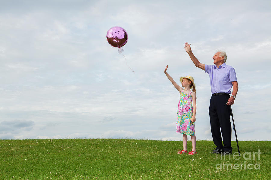 Summer Photograph - Girl and her grandfather releasing a helium balloon by Conceptual Images