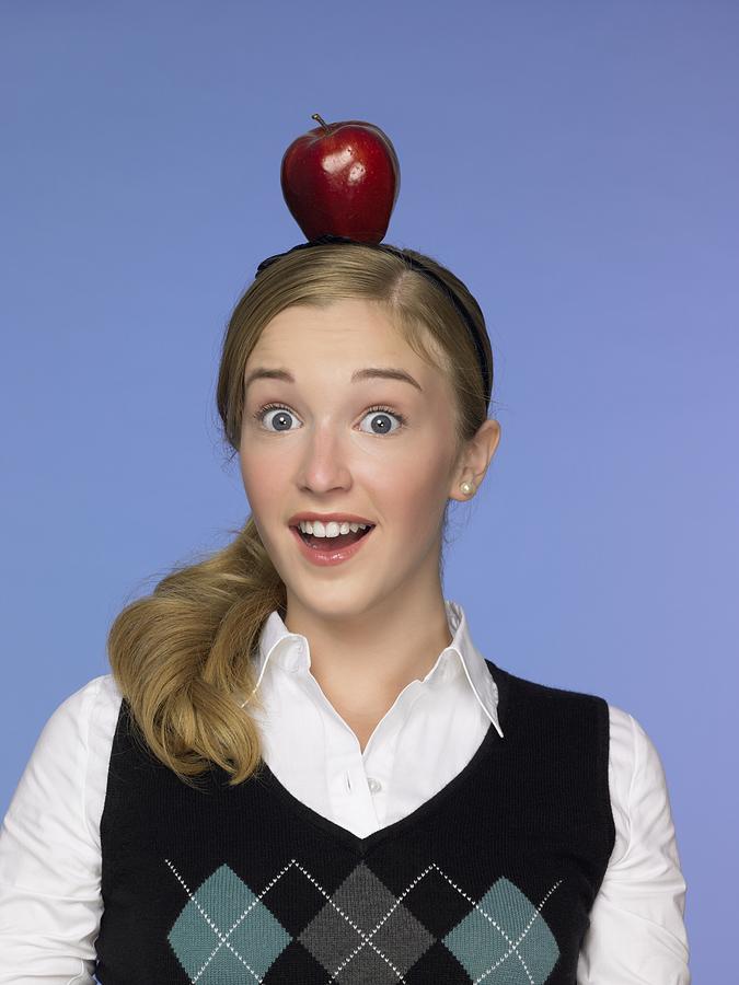 Girl balancing an apple on her head Photograph by Image Source