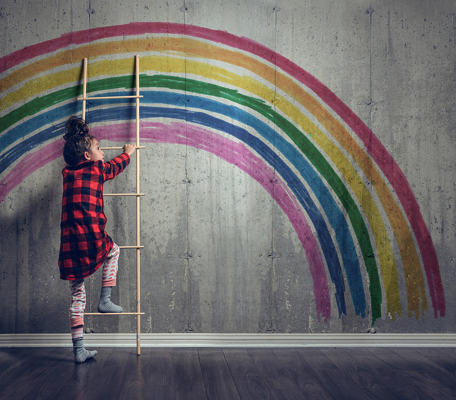 Girl climbing to reach the rainbow Photograph by Warchi