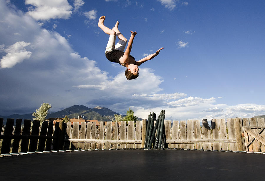 Girl doing backflip outdoors on a trampoline Photograph by Dorie Hagler